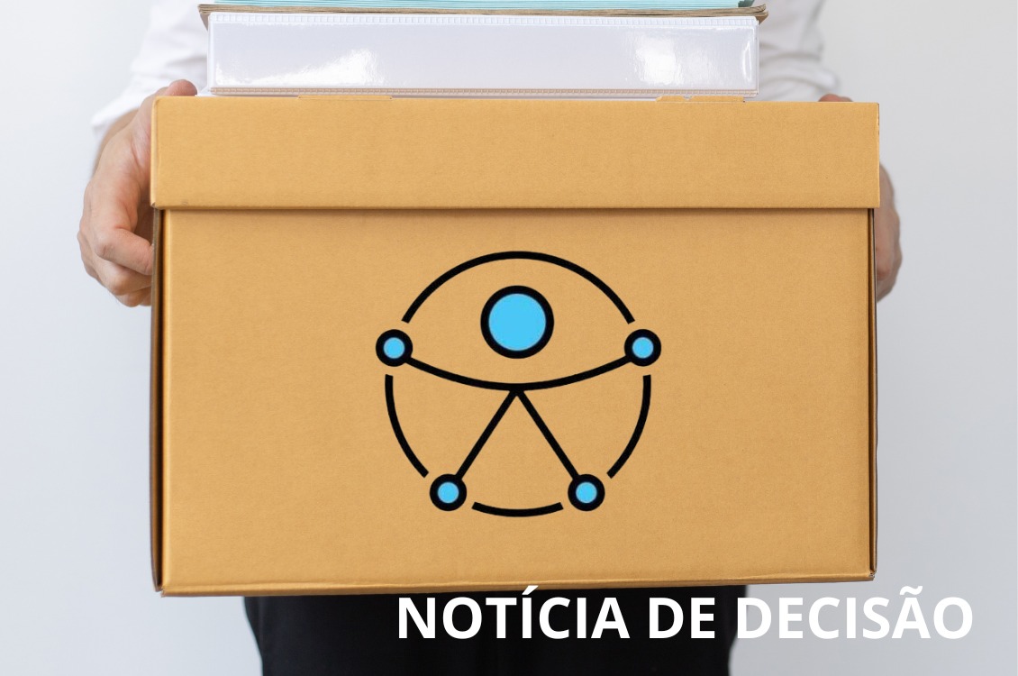 homem segura caixa com itens de escritório. Na caixa, o novo símbolo da acessibilidade.