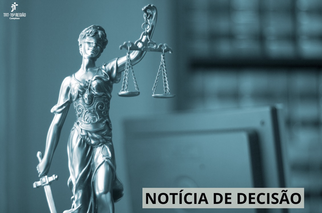 foto em tons de cinza com a estátua da Justiça do lado esquerdo da tela e um computador do lado direito