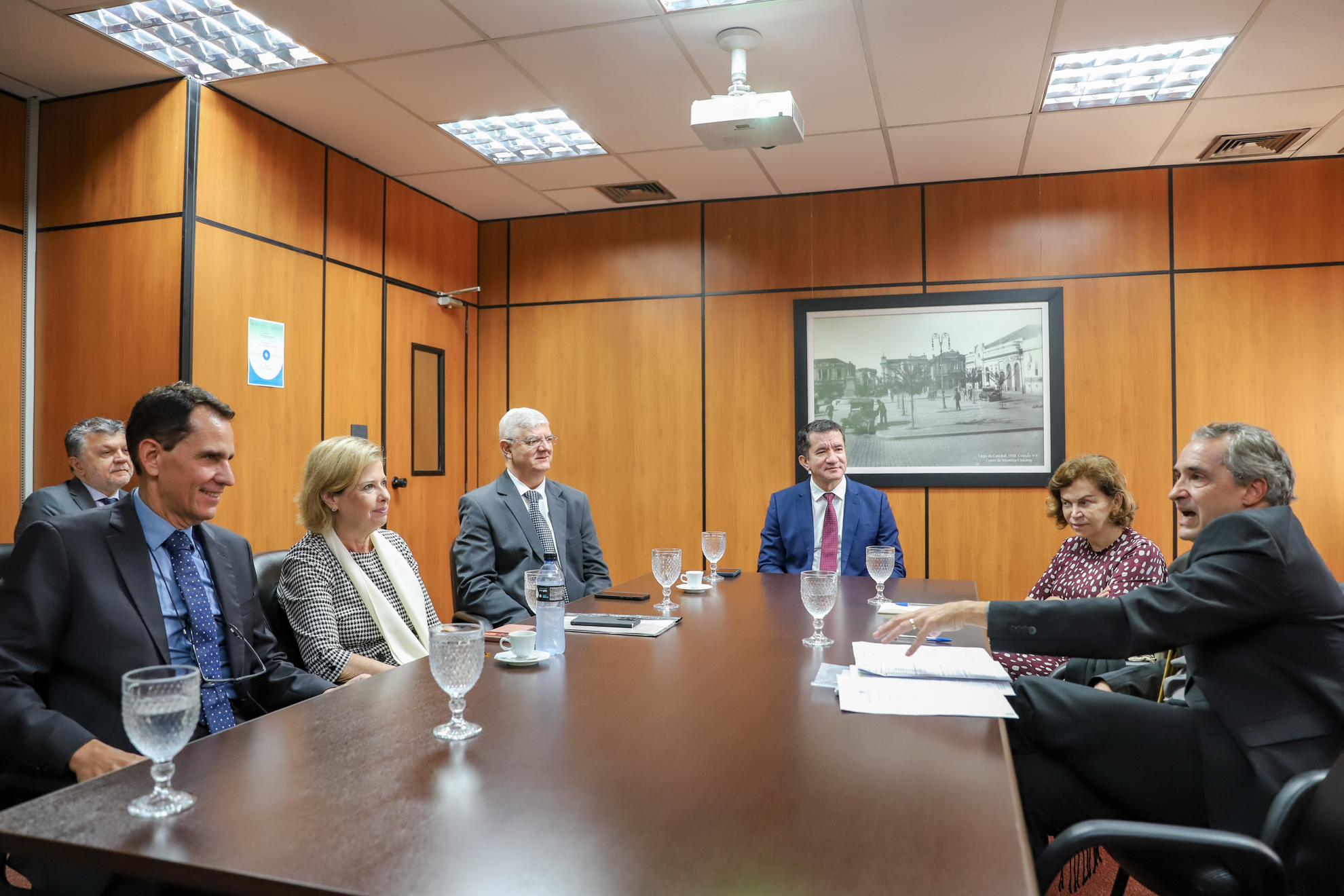 duas mulheres e quatro homens sentados à mesa retangular de madeira em sala de reunião na Corregedoria