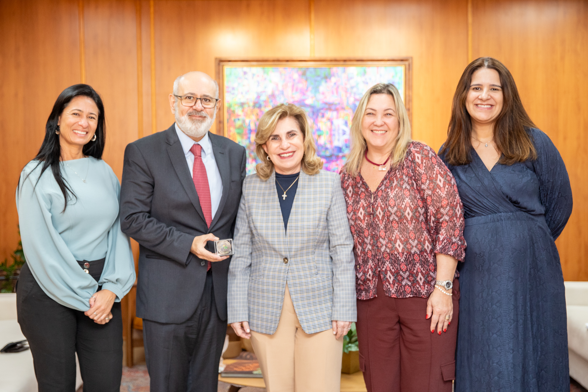 foto posada da Dra. Ana Paula com Luiz Costa segurando a medalha, acompanhados de Karina as advogadas Marcela e Simone