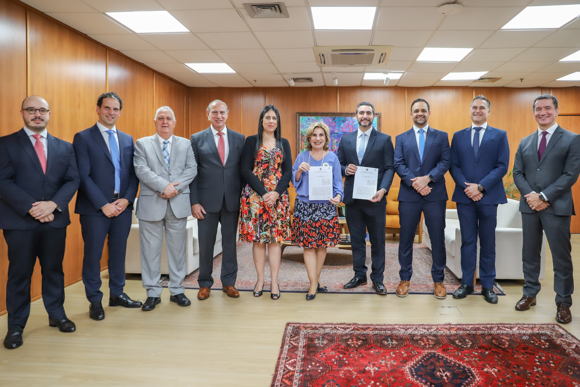 participantes de pé com Dra. Ana Paula e Jefferson Nurbegovic segurando o termo assinado