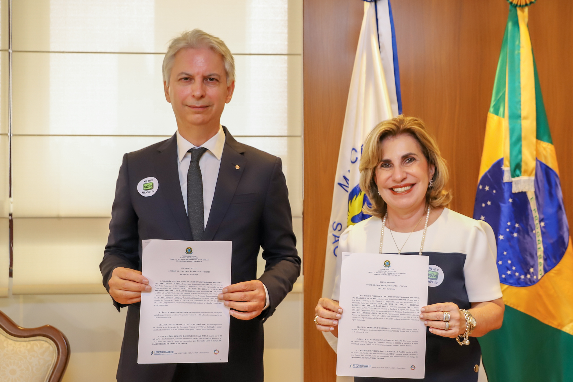 Ronaldo Lira e Ana Paula Lockmann posam para foto segurando o termo assinado